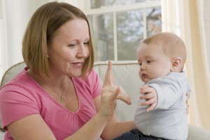 Woman signing the phrase 'I Love You ' in American sign language while communicating with her son © Mark Hunt/Disability Images