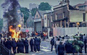 Brixton riots, London 1981. Police advance on barricades in Railton Road as they clear the streets.© David Hoffman
